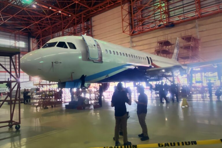 Collapsed airplane in hangar, B&H Worldwide logistics and aerospace operations, aircraft maintenance and transport services.
