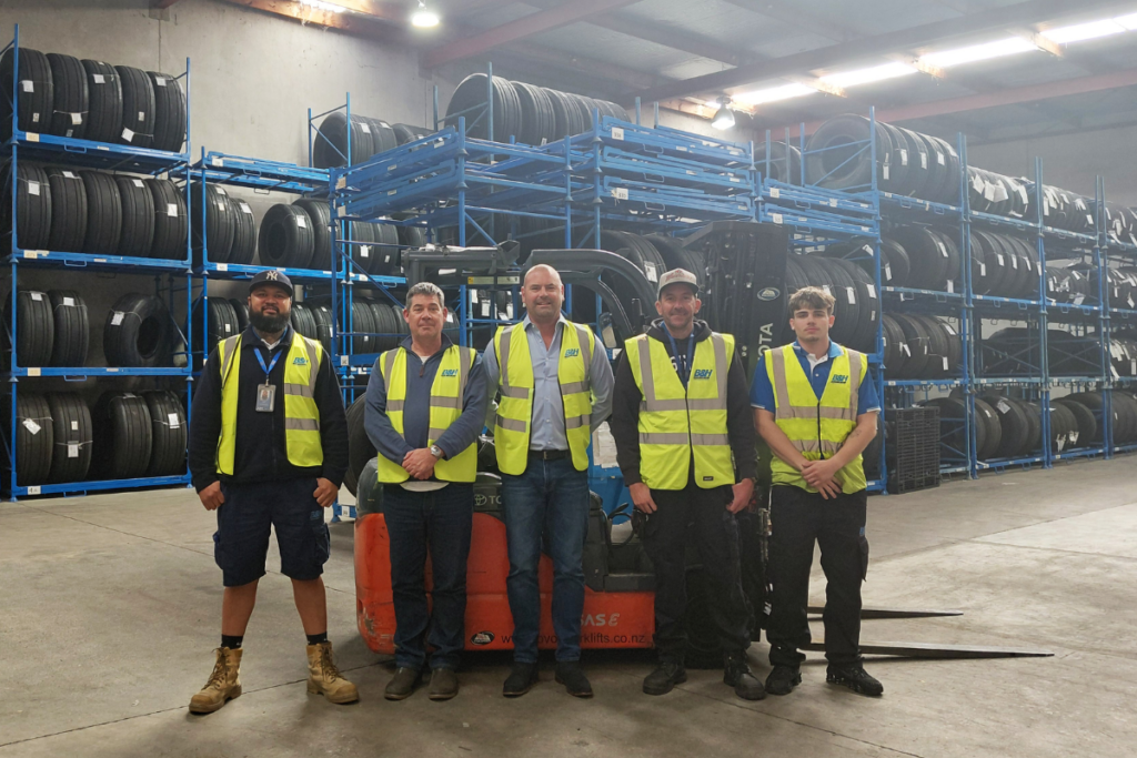 B&H Worldwide team in Auckland warehouse with tyres and storage racks.